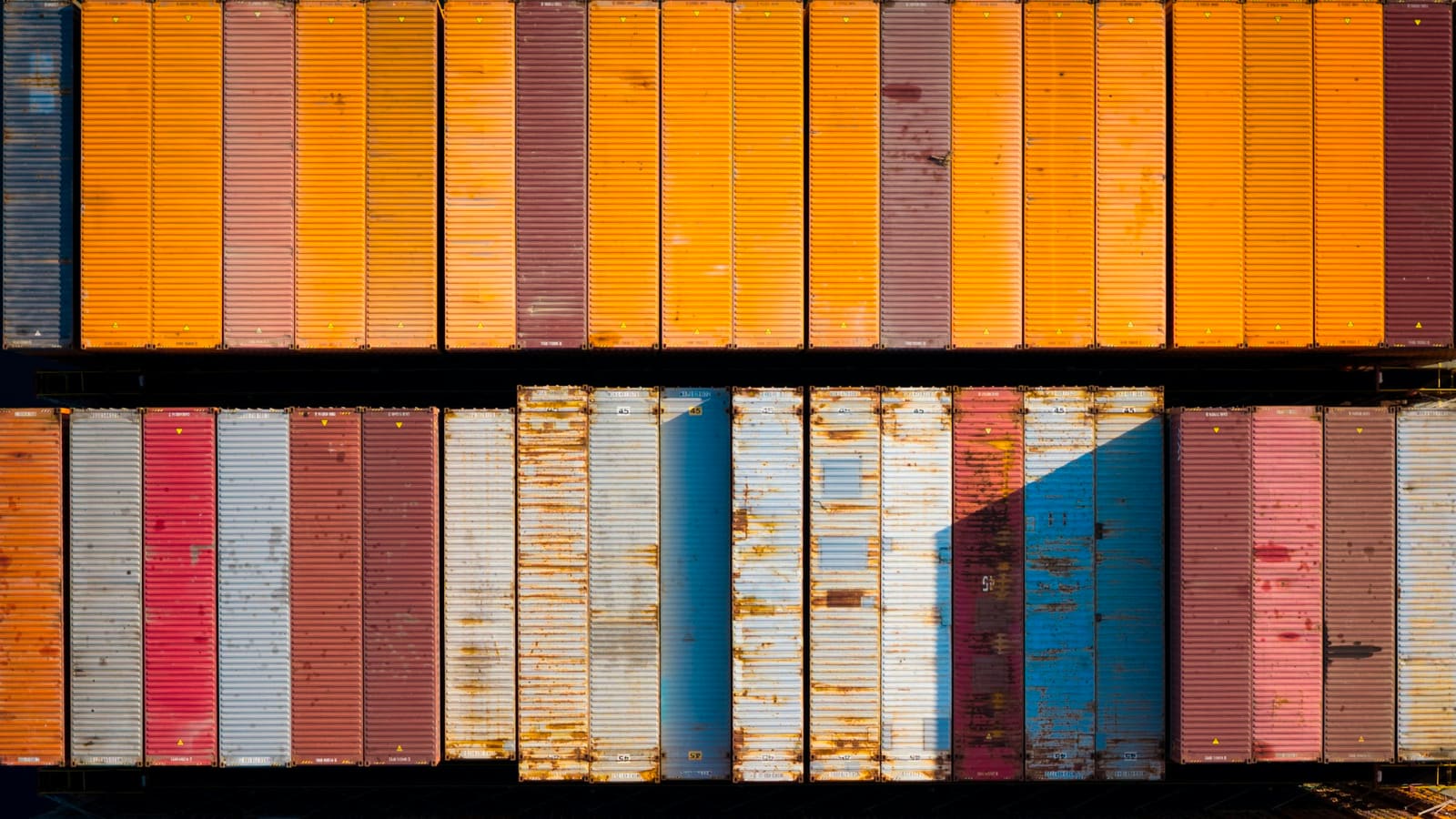 Top down view of colourful shipping containers stacked in tidy rows